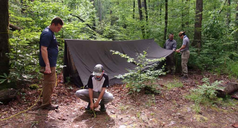 people assemble a shelter on an outward bound expedition for families in north carolina